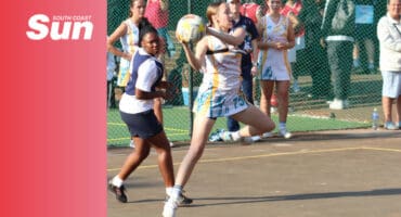 a netball player leaping off the ground in a court