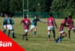 a rugby match going on, player with the ball is kicking it