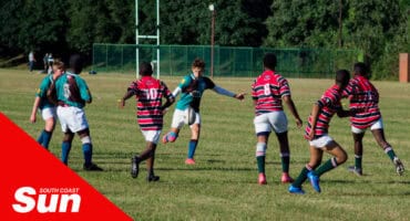 a rugby match going on, player with the ball is kicking it