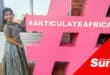 a little girl next to a large hashtag statue