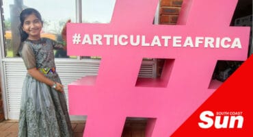 a little girl next to a large hashtag statue