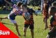 a young minis rugby player weaving past a defender during his run