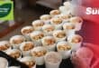 Meals packed into take away containers lined in rows on a counter top
