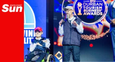 a disabled person accepts a tourism award with his able-bodied father