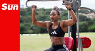 a female bodybuilder makes use of outdoor gym equipment