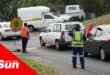 traffic slowly moving, being guided by traffic officers. cars driving over a low-profile metal speed bump