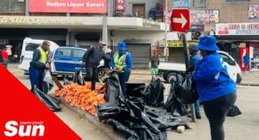 metro police confiscating a street hawker's stock of oranges with black bags