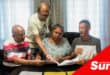 A group of flat residents look through a document together