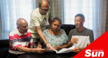 A group of flat residents look through a document together