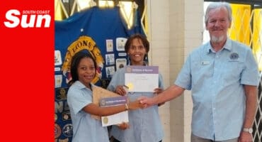 a young woman is handed a certificate of induction by two club members