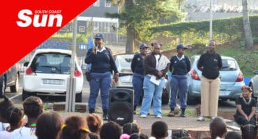 policemen speaking on stage at a school assembly