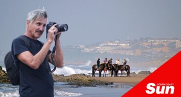 a photograph of horses on the beach, inset of a photographer