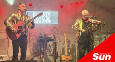 a guitarist and violinist on stage performing at a music show
