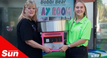 a woman receiving a candy floss machine donation from another woman