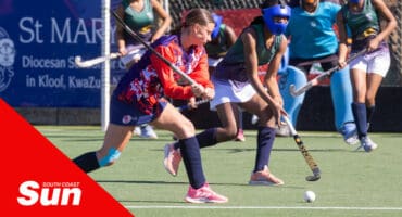 a schoolgirls' hockey tournament. a player moves in to score a goal