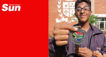 a sports learner at a school shows off his martial arts medal