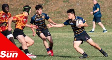 A Lancaster Grammar School player holds back Amanzimtoti's defensive line.