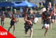 young rugby players on the field. player with possession of the ball is running ahead of the pack