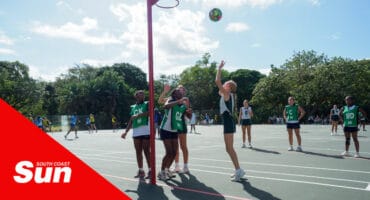 a netball tournament being played, with one player taking a shot