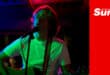 a musician plays guitar and sings on stage