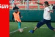 a soccer player with possession of the ball taunts a defender