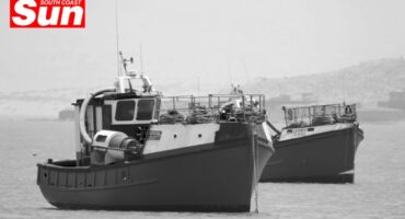 a photograph of multiple boats at a dock, taken in black and white
