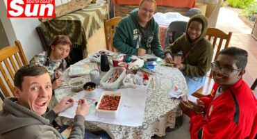 a group photograph around a round table at a neurodivergent skills training and learning centre