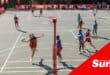 a high angle courtside view of a schoolgirls' netball game