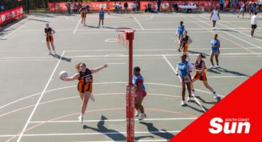 a high angle courtside view of a schoolgirls' netball game