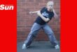 a child dancing in front of a brick wall