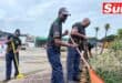 two men use rakes to brighten up and beautify a garden