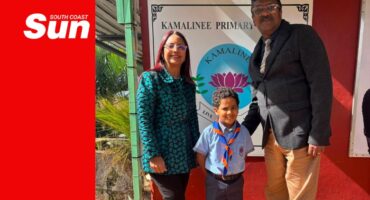 a group photograph with two educators and a school learner in his scout attire.