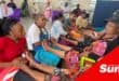 elderly women receiving foot massages from volunteers