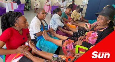 elderly women receiving foot massages from volunteers