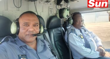 two men take a photograph in a helicopter