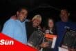 a group of fisherfolk show off their prizes after a competition