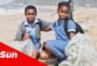 two children with refuse bags during a beach cleanup