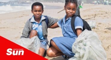 two children with refuse bags during a beach cleanup