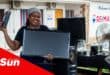 a woman holds a monitor and a remote during an electronic waste recycling drive