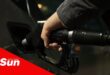 a person using a bowser to fill fuel in his car