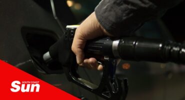 a person using a bowser to fill fuel in his car