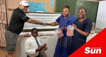 a group photograph with donated food in front of a freezer