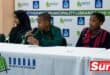 multiple children, one with a microphone in his hands answering a question