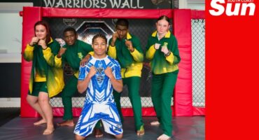 a group photograph of mixed martial artists in a dojo on a sparring mat