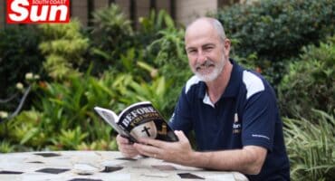 a man sitting on a bench reading a book