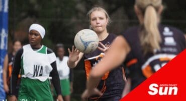 a netball player passes the ball to her teammate