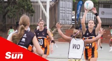 on a netball court, a defender passes the ball to an attacker
