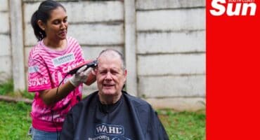 a woman shaving a man's head for a cancer shavathon