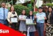 a group photograph with children holding up their prizes from a recycling fair