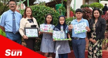 a group photograph with children holding up their prizes from a recycling fair